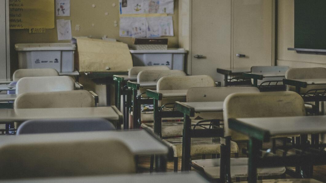 Lege schooltafels en -stoelen in een klaslokaal