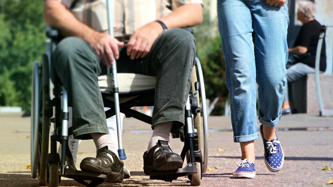 Benen van persoon in rolstoel en lopend persoon
