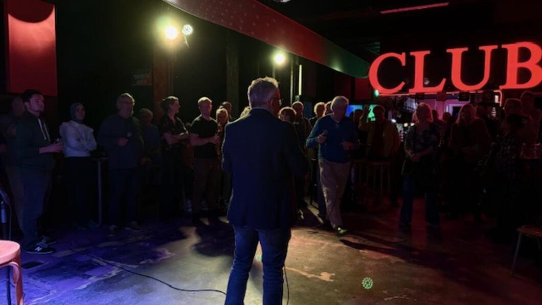 Donkere omgeving met omtrek van personen lichtgevende letters CLUB op de achtergrond