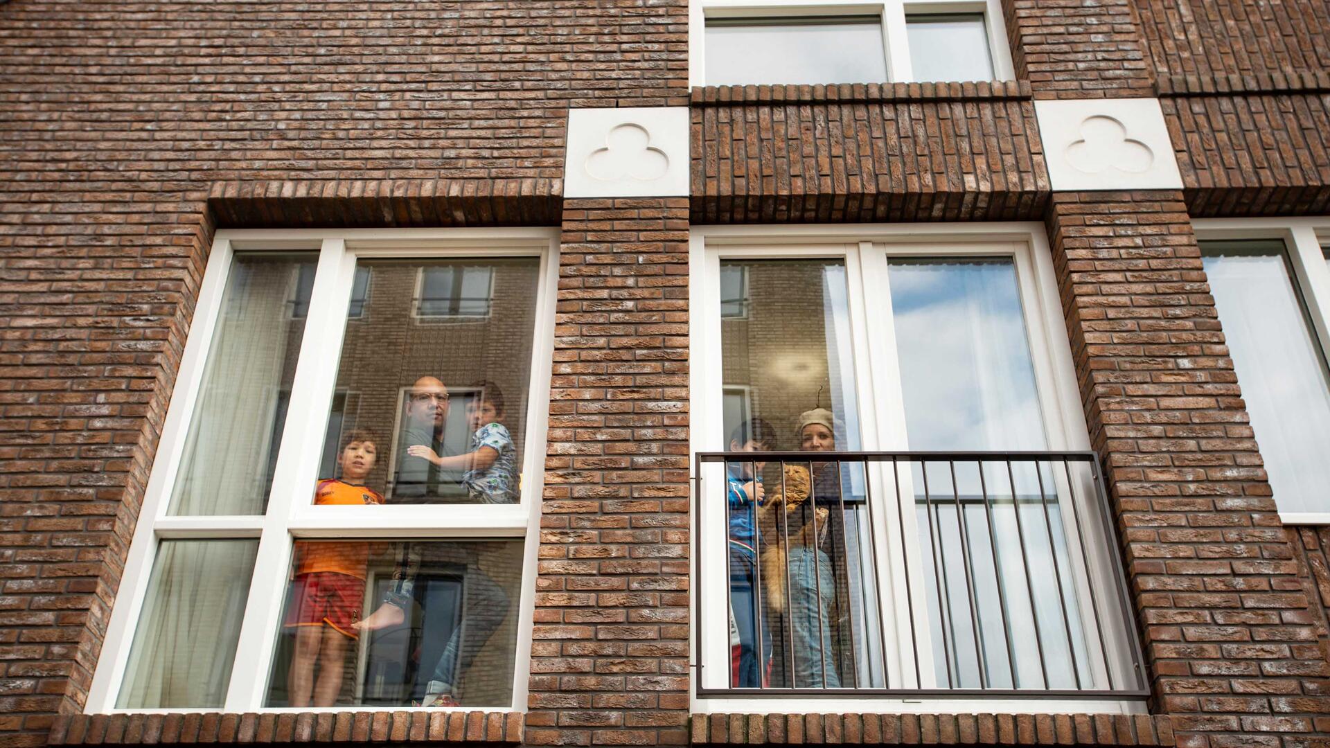 Mensen kijken uit hun woning.