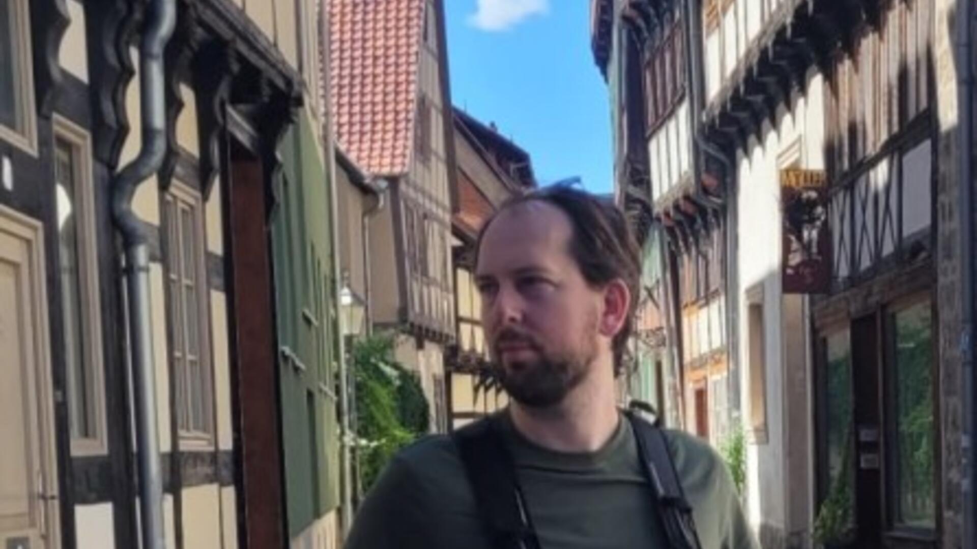 Jens met rugzak in een straat met vakwerkhuizen