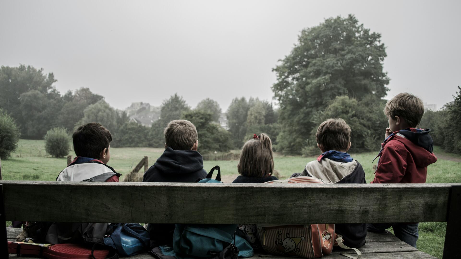 Kinderen op een houten bank vanaf de rug gezien