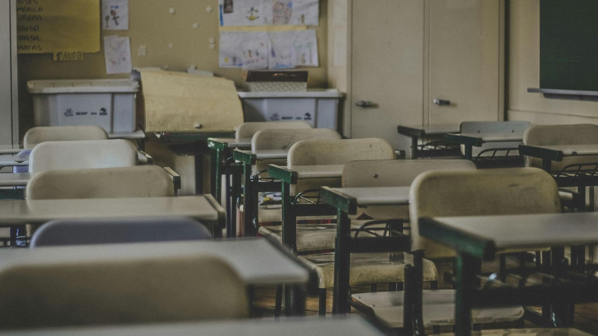 Lege schooltafels en -stoelen in een klaslokaal